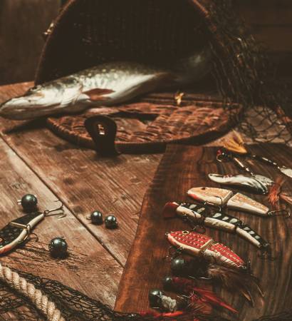 Fishing tools and fresh pike on a wooden table Fishing tools and fresh pike on a wooden table